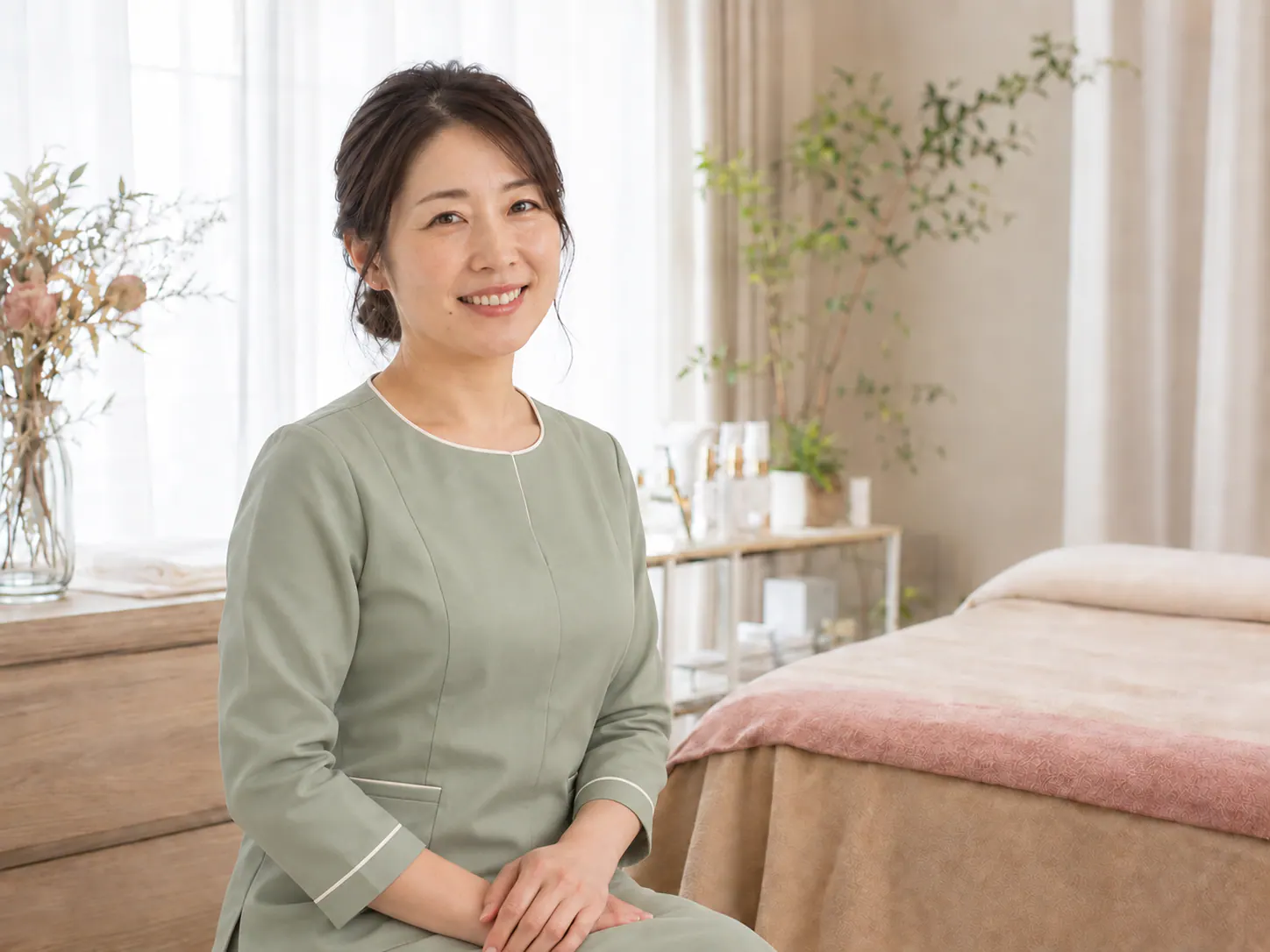 白を基調としたまつげサロンに立つ女性オーナー
