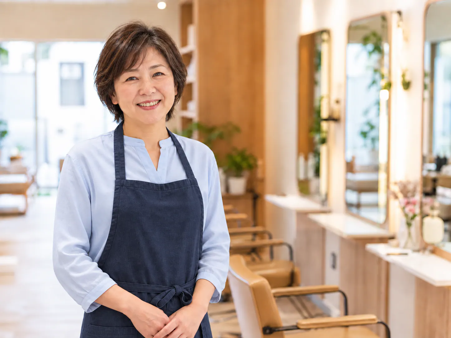 木目調の美容室で微笑む女性オーナー